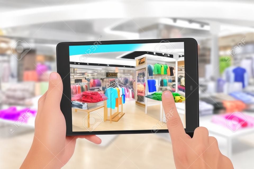 Augmented reality concetto di marketing. Mano che tiene tavoletta digitale applicazione AR uso smart phone per controllare speciale prezzo di vendita nel centro commerciale negozio di moda al dettaglio