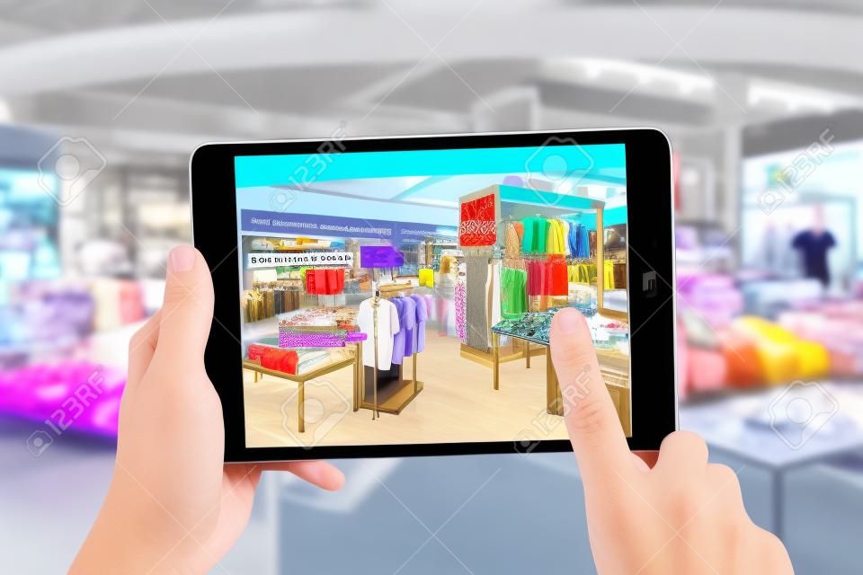 Augmented reality marketing concept. Hand holding digital tablet smart phone use AR application to check special sale price in retail fashion shop mall