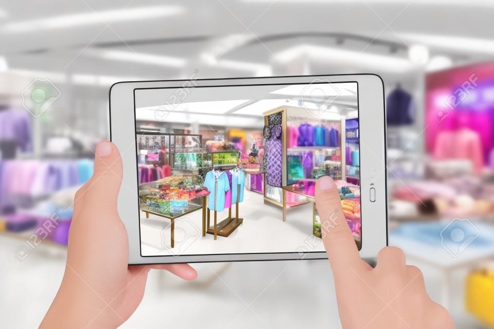 Augmented Reality-Marketing-Konzept. Hand hält digitalen Tablet intelligente Nutzung AR-Anwendung Telefon speziellen Verkaufspreis im Einzelhandel Modegeschäft Mall zu überprüfen