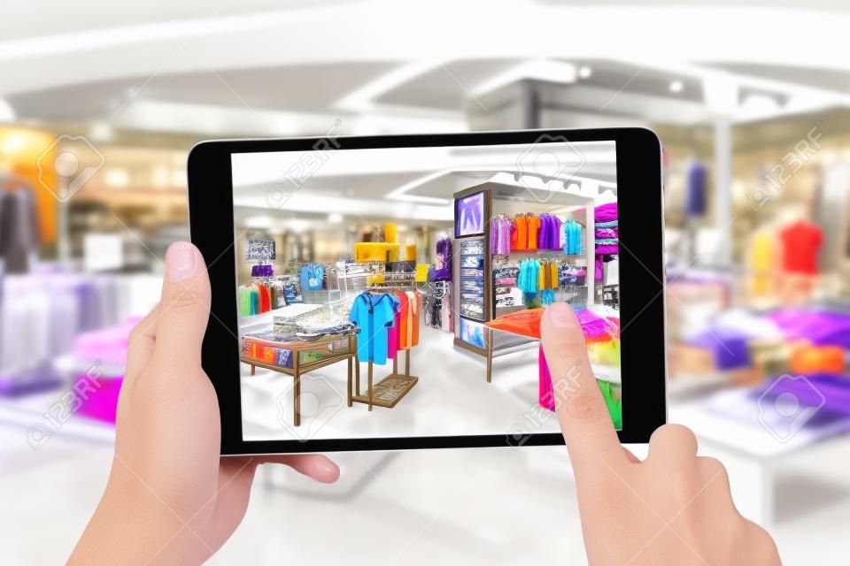 Augmented Reality-Marketing-Konzept. Hand hält digitalen Tablet intelligente Nutzung AR-Anwendung Telefon speziellen Verkaufspreis im Einzelhandel Modegeschäft Mall zu überprüfen