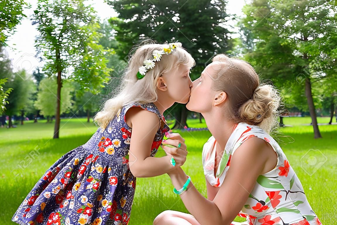 美麗的女孩親吻她的母親在公園裡