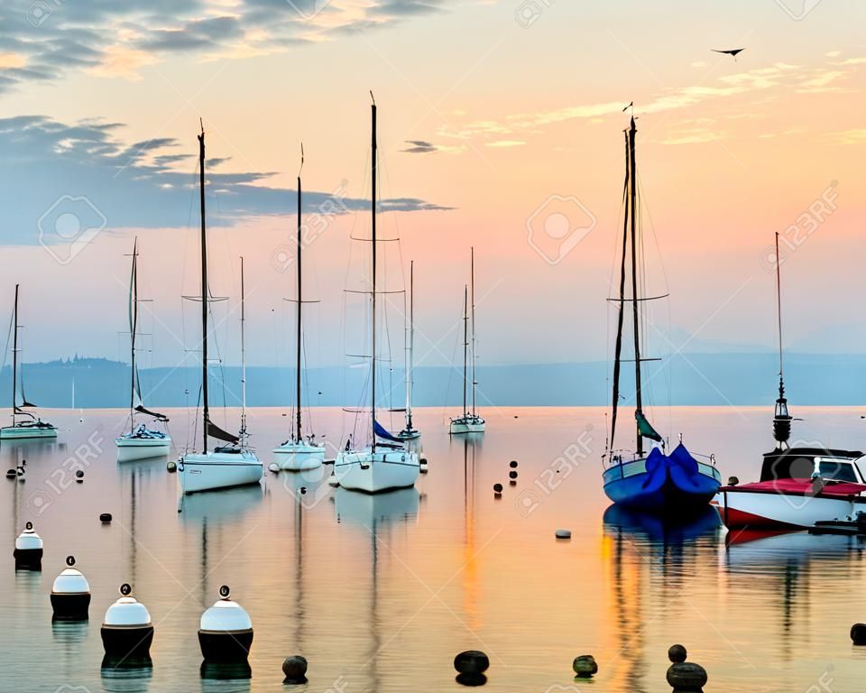 Lever du soleil au bord du lac de Genève, en Suisse avec des voiliers et des yachts