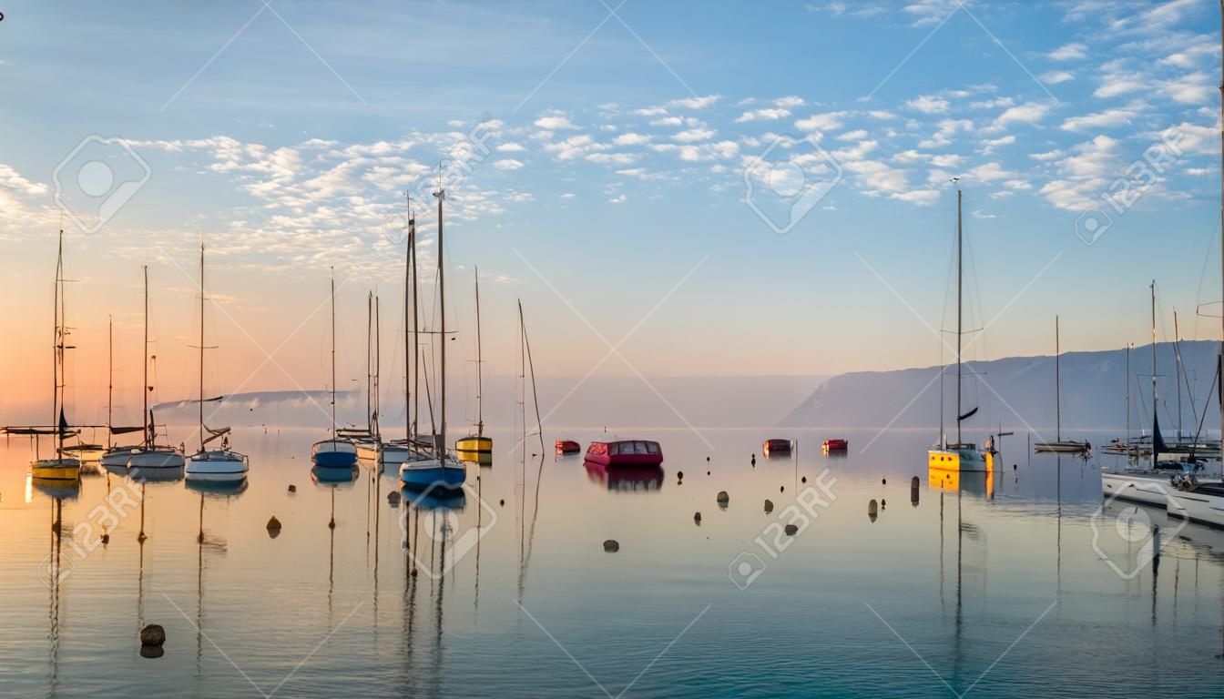 Lever du soleil au bord du lac de Genève, en Suisse avec des voiliers et des yachts