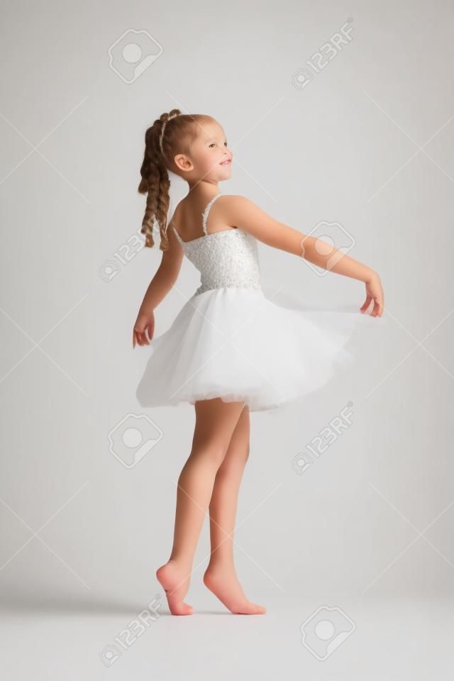 Beautiful little girl dancing on a white background