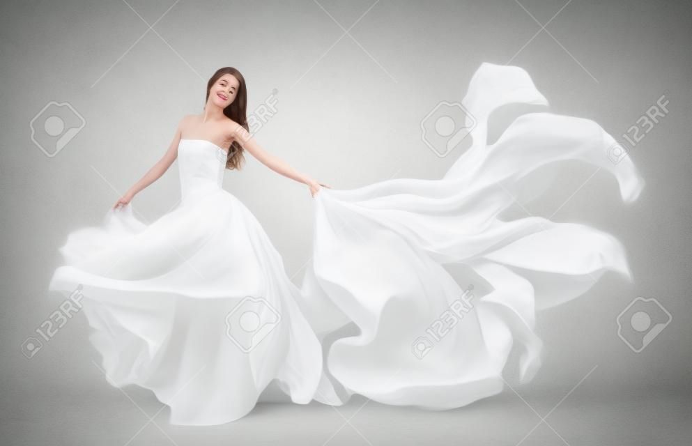 piękna młoda dziewczyna w białej sukni latania. Tkanina płynących