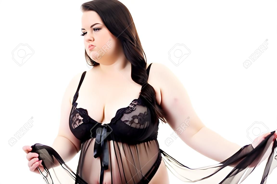 Plus Size dicke Frau trägt schwarze Spitze Dessous Babydoll. Übergewichtiges übergroßes überessendes molliges fettleibiges Modell in Unterwäschekleidung auf weiß