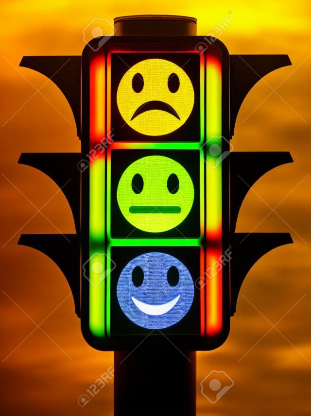 Les feux de circulation avec trois humeur visages sur une rouge vert et d'ambre