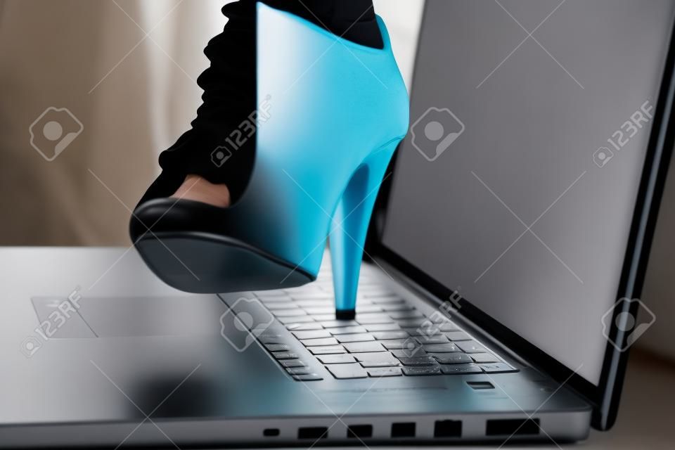 Una donna si prepara a schiacciare il suo computer portatile con il suo tallone