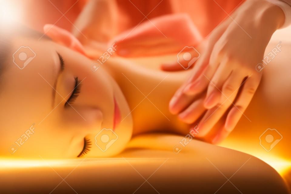 La hermosa chica tiene masaje. Imagen auténtica de un tratamiento de spa de lujo. Colores cálidos, luz encantadora.