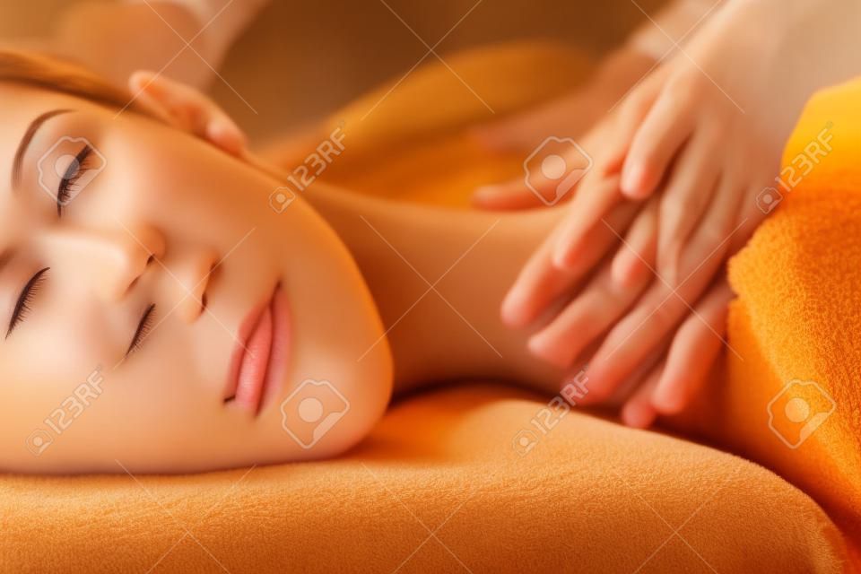 La hermosa chica tiene masaje. Imagen auténtica de un tratamiento de spa de lujo. Colores cálidos, luz encantadora.