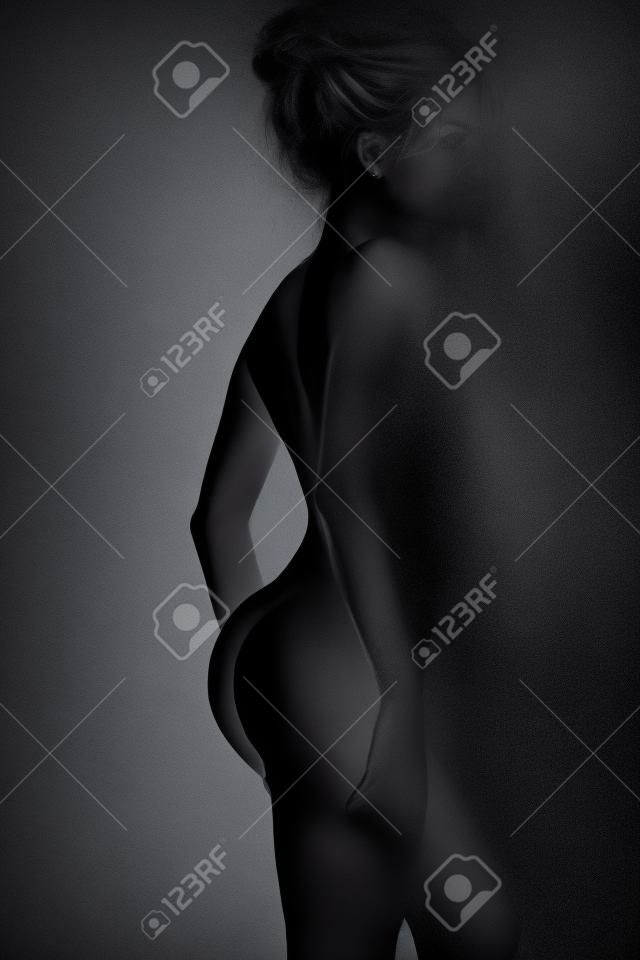 young beautiful female body on a dark background