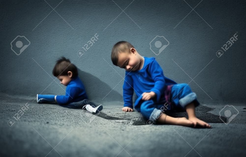 Allein trauriges Kind spielt auf einer Straße