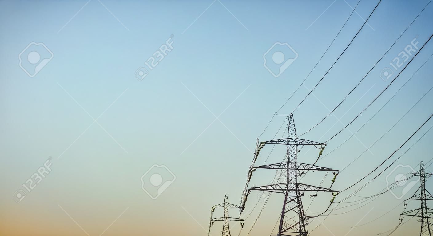 A linha elétrica de eletricidade de alta tensão eleva-se contra o céu. torres de transmissão