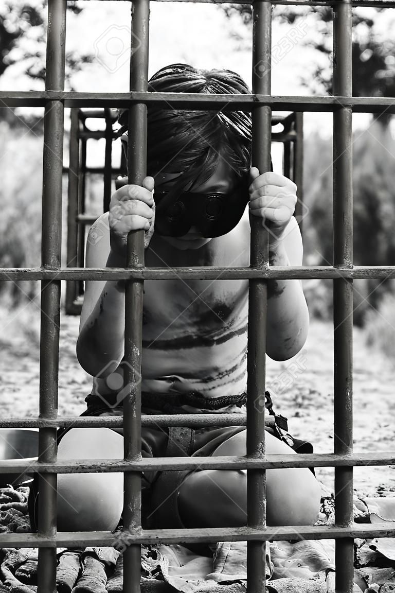 소년은 감옥에 있습니다. 포획된 인간 아이. 납치와 인신매매의 개념.