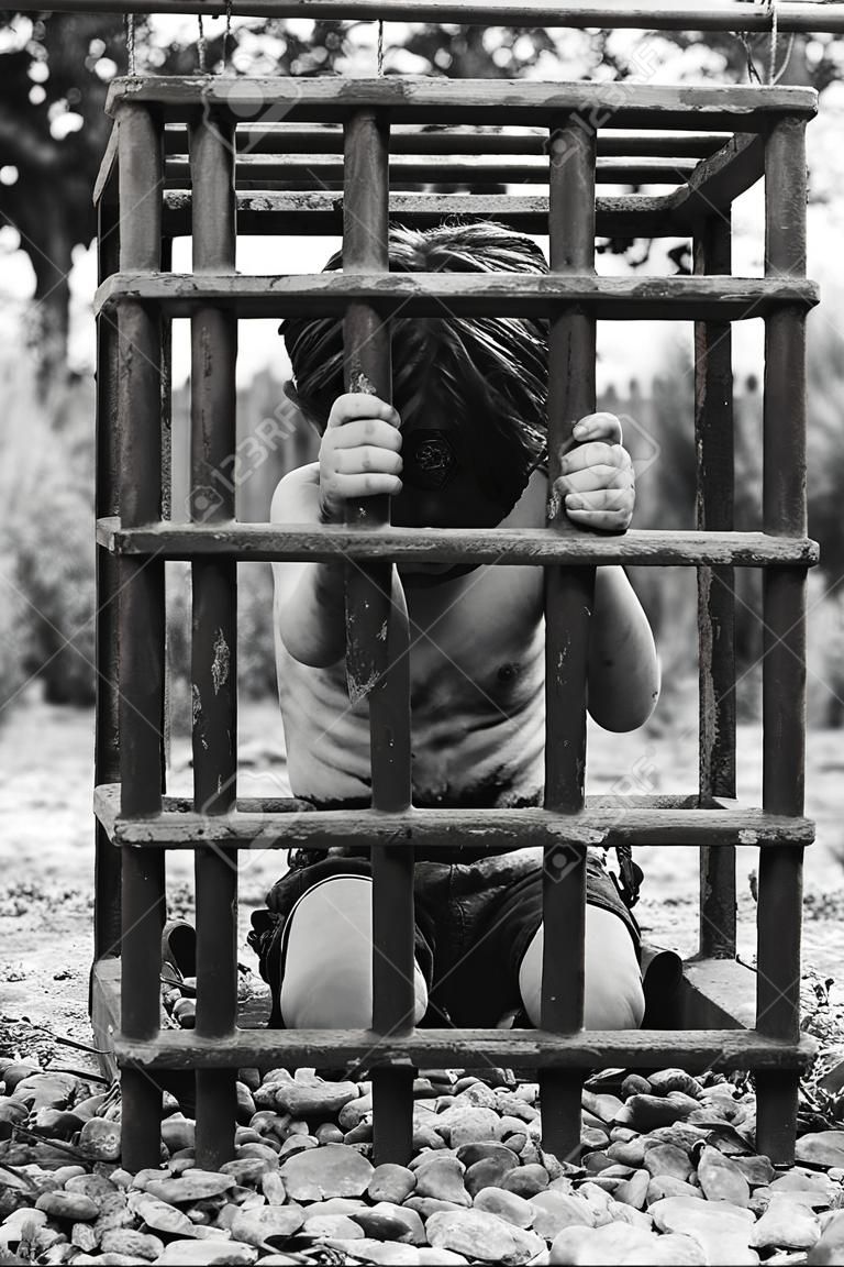 Le garçon est en prison. Enfant humain capturé. Le concept d'enlèvement et de traite des êtres humains.