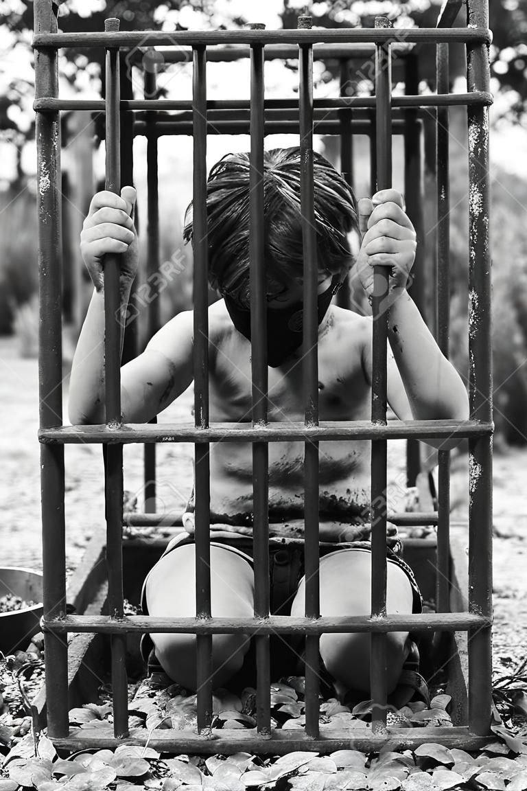 The boy is in prison. Captured human child. The concept of abduction and human trafficking.