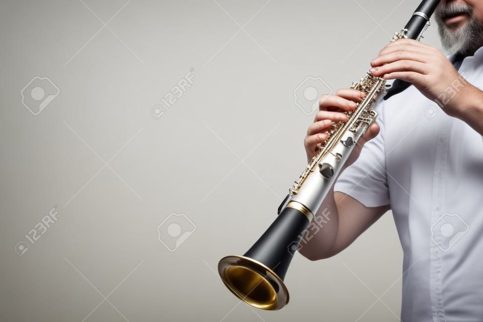 Mani del giocatore del clarinetto che giocano strumento musicale classico. Strumenti a fiato isolati su bianco