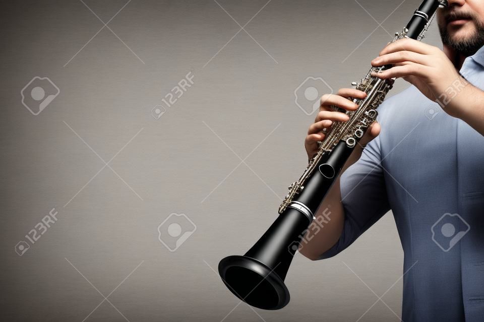Mani del giocatore del clarinetto che giocano strumento musicale classico. Strumenti a fiato isolati su bianco