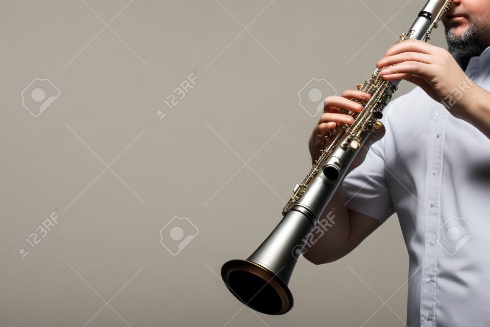 Manos de jugador de clarinete tocando instrumento musical clásico. Instrumentos de viento de madera aislados en blanco