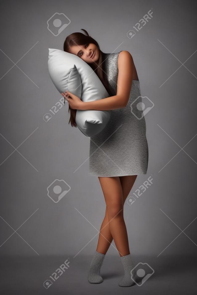 Hermosa chica adolescente sosteniendo una almohada estudio tiro
