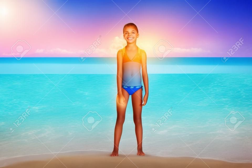 Gyermek pózol egy trópusi strandon során a nyári vakáció