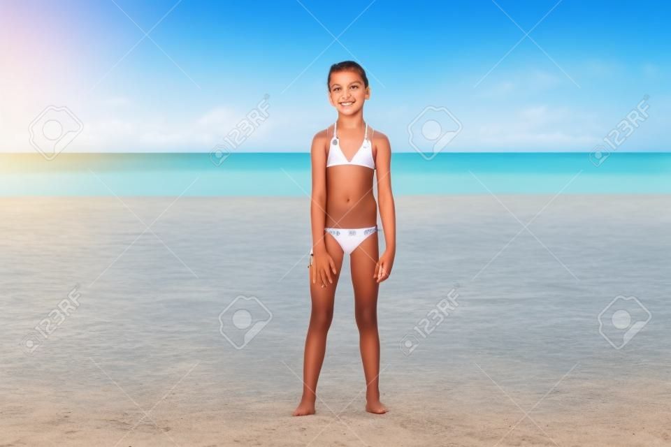 Enfant posant sur une plage tropicale pendant les vacances d'été