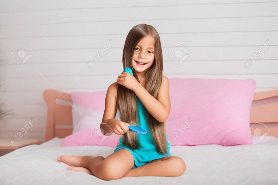 9 歳の女の子の朝に彼女の寝室で彼女の長い髪をブラッシング