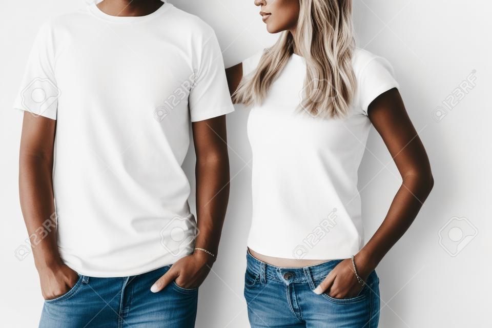 Two hipster models man and woman wearing blanc t-shirt, jeans and sunglasses posing against white wall, toned photo, front tshirt mockup for couple