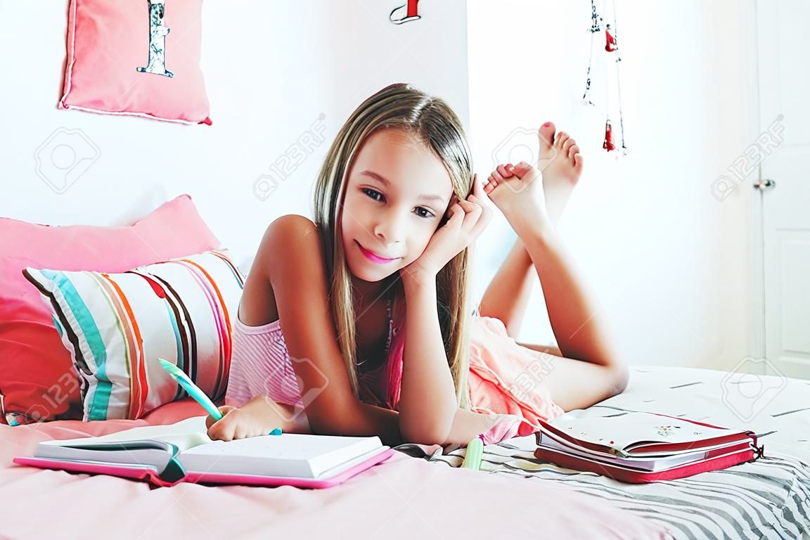 Diario de 10-12 años de edad pre escritura de la muchacha adolescente en la habitación de color rosa