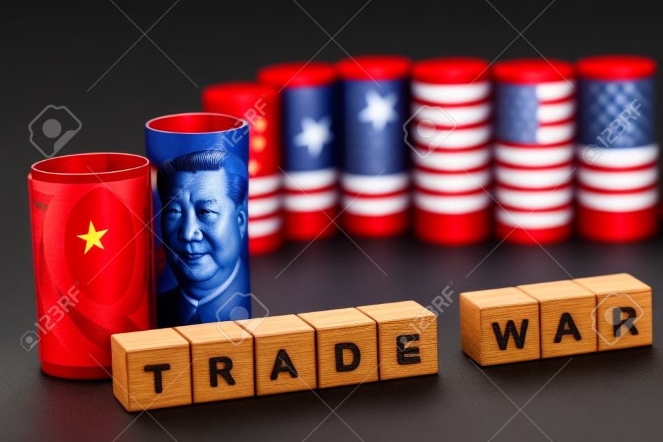 Libellé de guerre commerciale entre la Chine et les États-Unis sur des cubes en bois avec des billets de banque en dollars américains et en yuans sur fond noir. La guerre commerciale est une barrière fiscale tarifaire entre la Chine et les États-Unis d'Amérique.