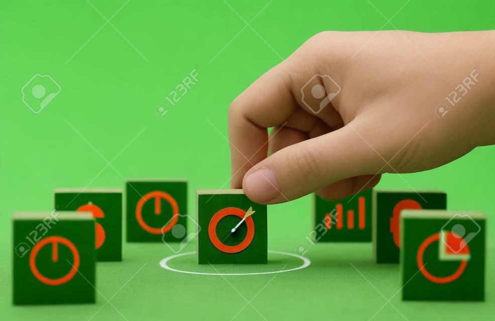 Mão colocando a placa do alvo com seta no fundo verde para configurar o alvo objetivo e o objetivo de investimento.