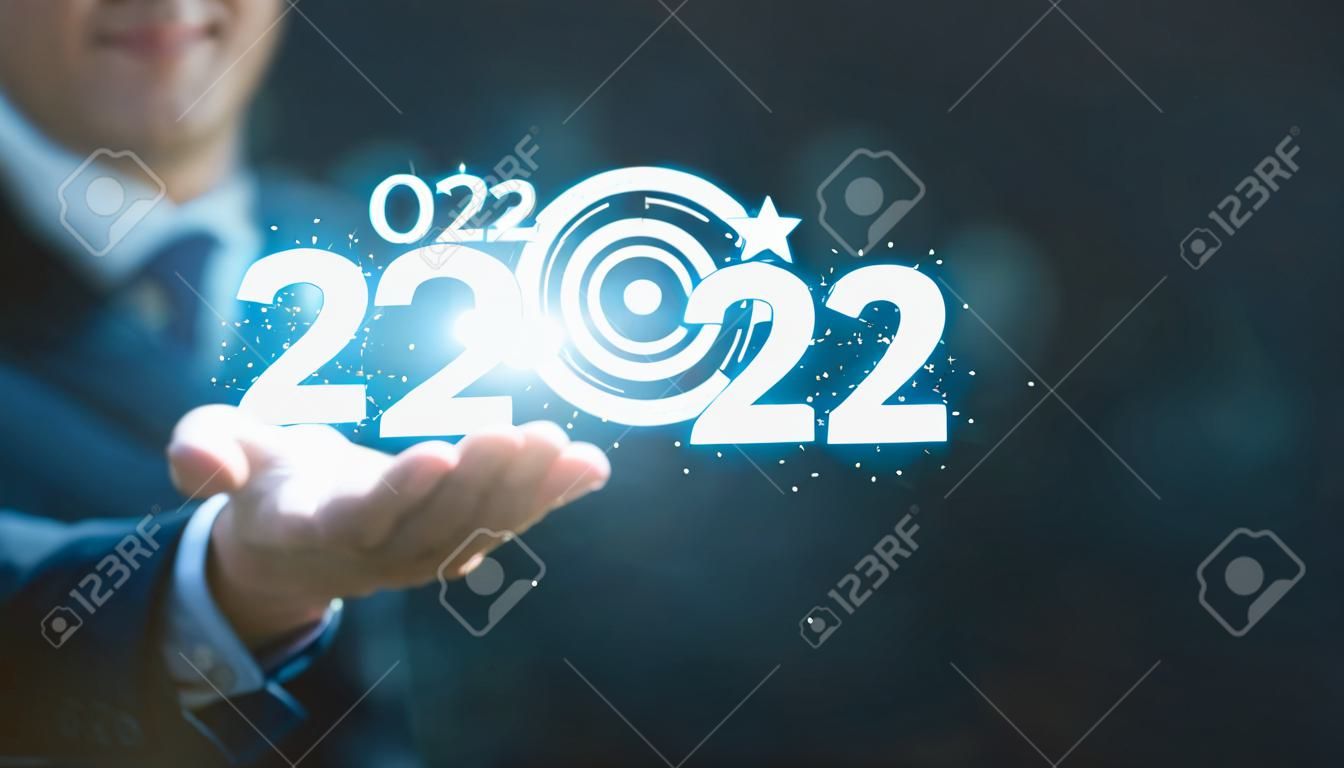 Uomo d'affari che tiene il numero virtuale 2023 con bersaglio per freccette blu e copia spazio per buon natale e felice anno nuovo, imposta un nuovo concetto di obiettivo obiettivo aziendale.