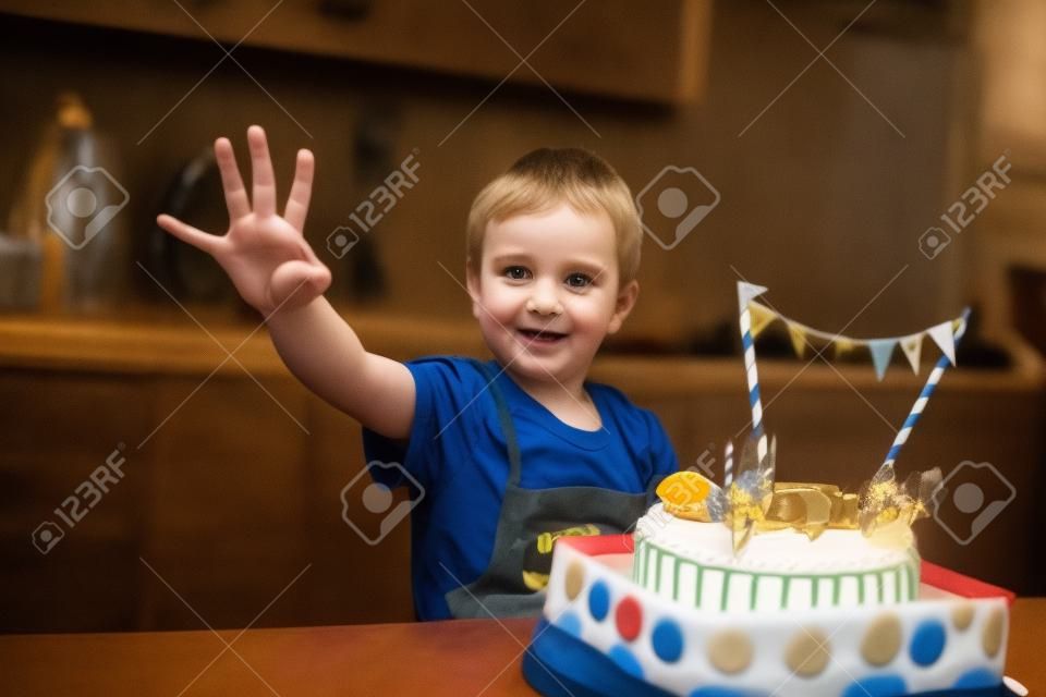 O menino senta-se com o bolo na mesa e mostra quantos anos ele tinha