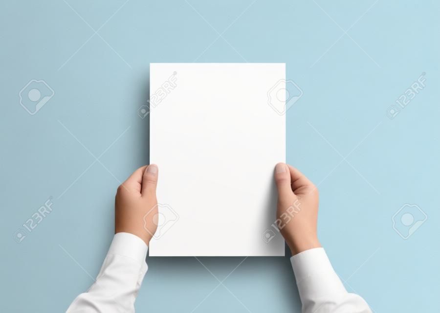 Hand holding white blank paper sheet mockup, isolated. Arm in shirt hold clear brochure template mock up. Leaflet document surface design. Simple pure print display show. Reading contract agreement.