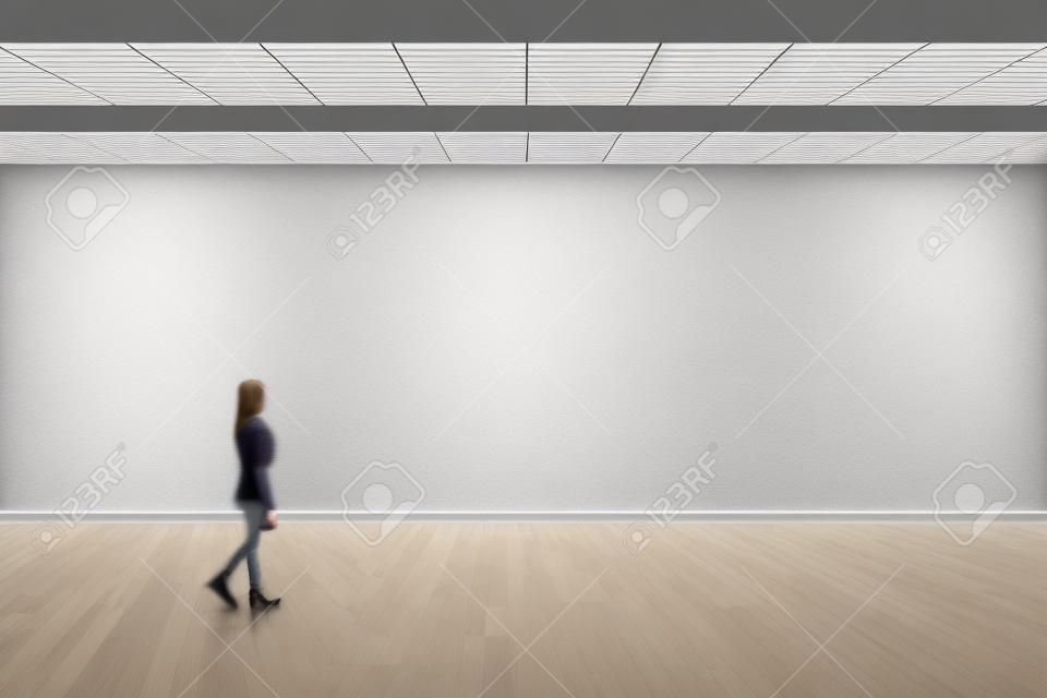 Макет стены пустой большой зал. Прогулка женщины в галерее музея с глухой стеной.
