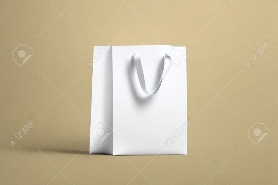 Sac-cadeau en papier blanc vierge avec maquette de poignée en soie dorée, rendu 3d. Maquette de paquet d'achat vide, isolé. Sac en plastique transparent à acheter ou à présenter. Beau modèle de package artisanal.