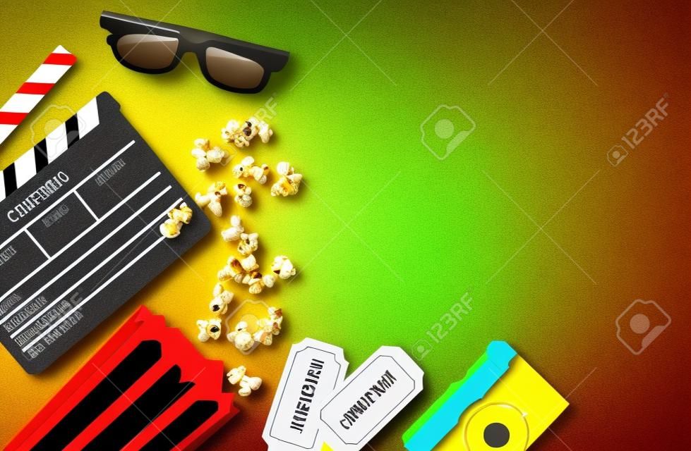 Conceito de festa de cinema. bilhetes de cinema, clapperboard, milho pop e óculos 3d em um amarelo