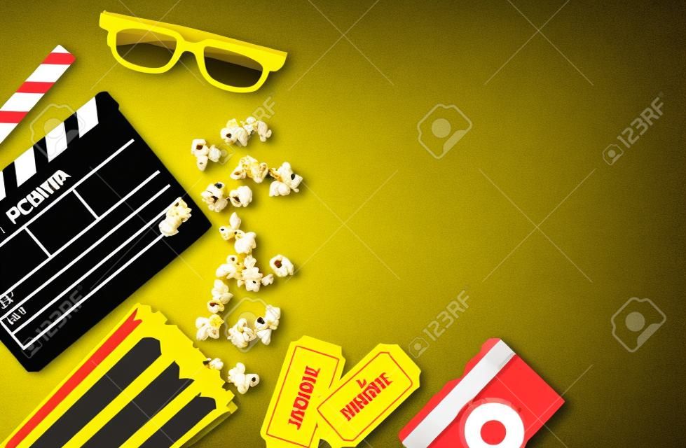 Conceito de festa de cinema. bilhetes de cinema, clapperboard, milho pop e óculos 3d em um amarelo