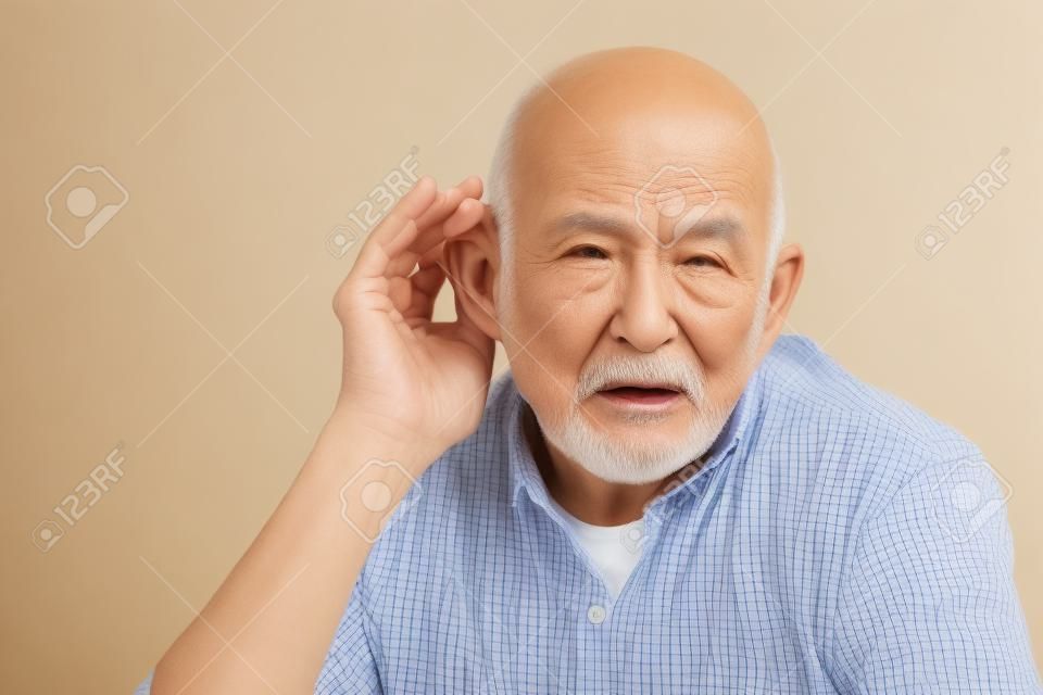 Senior uomo cupping suo orecchio con difficoltà uditive