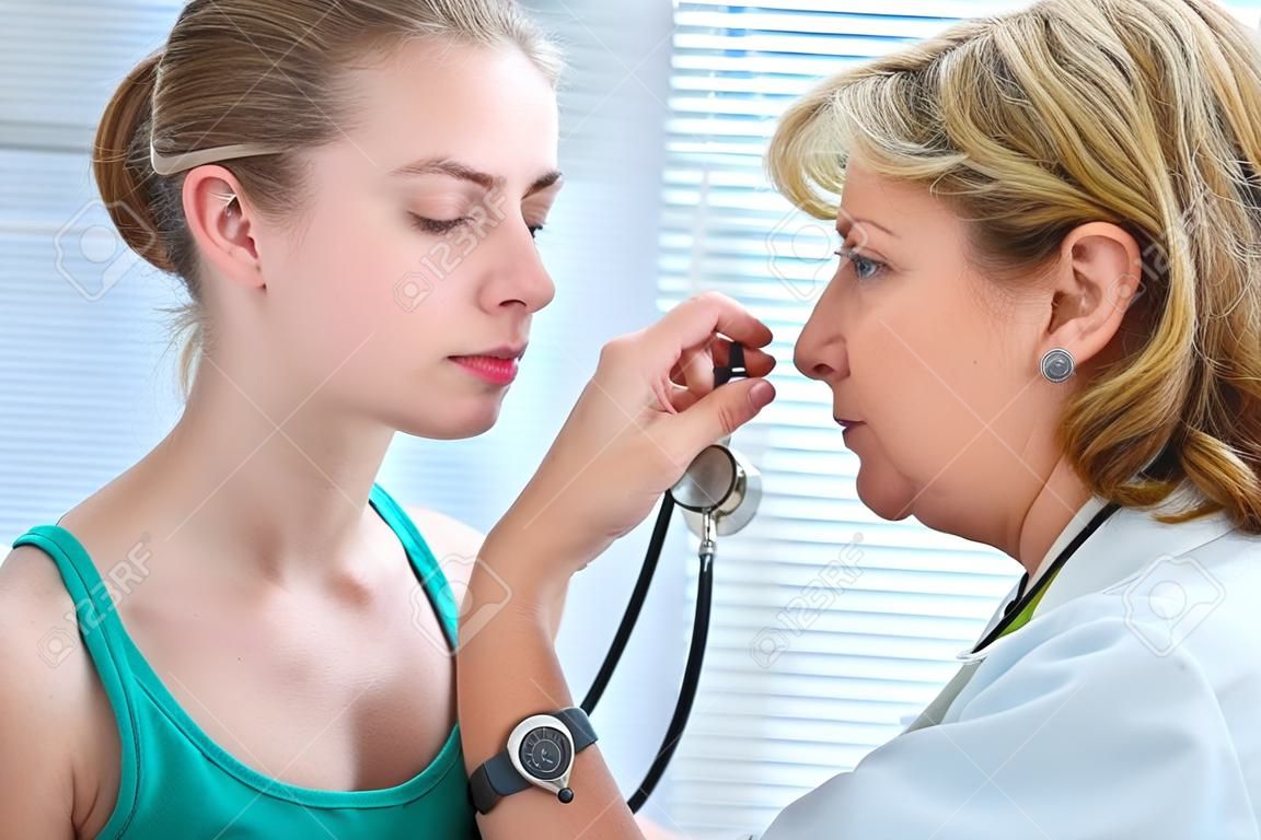 Doctora examinando adolescente con estetoscopio