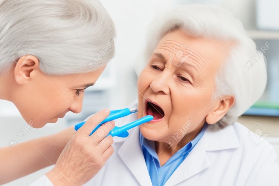 Il medico esamina donna anziana per mal di gola