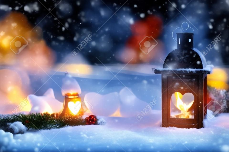 Christmas background with burning lantern in the snow