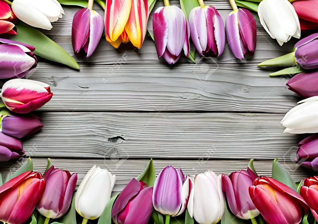 Rama ze świeżych tulipanów umieszczone na starym drewnianym tle