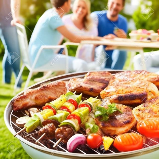 Famiglia avendo un barbecue party nel loro giardino in estate