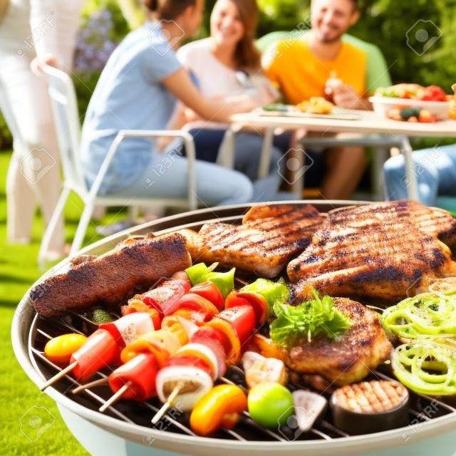 Familie die een barbecue feestje in hun tuin in de zomer