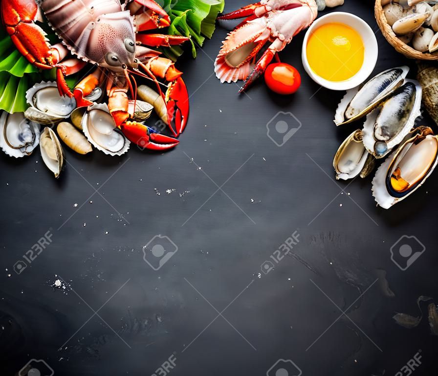 Skorupiaków talerz owoców morza, skorupiaków świeżego homara, małże, ostrygi jako znakomitą kolację tle oceanu