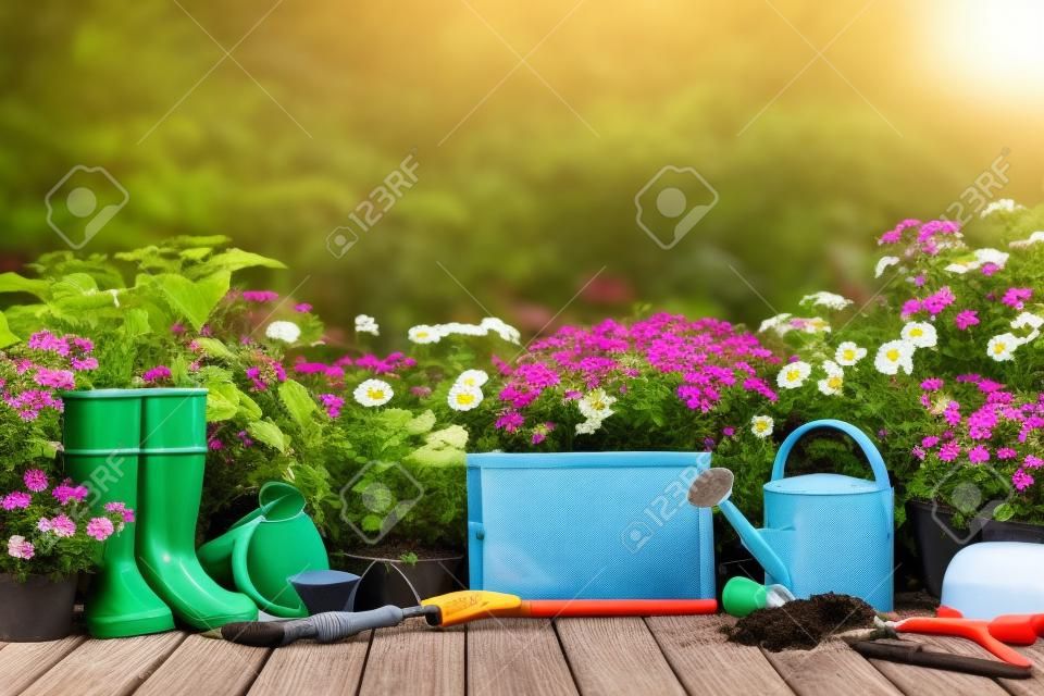 Herramientas de jardinería y flores en la terraza en el jardín