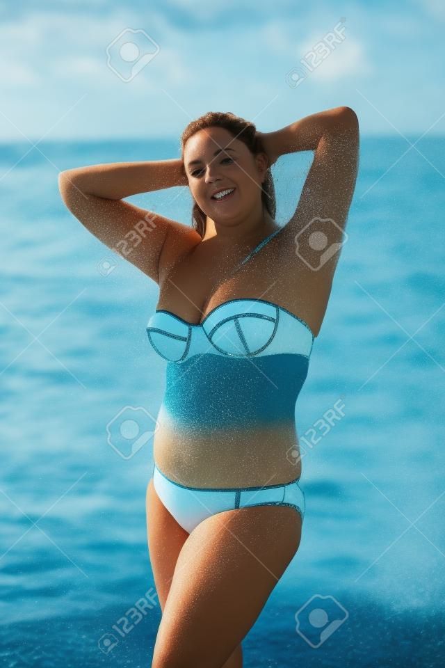 Kobieta w strój kąpielowy na morzu. Nadwaga młoda kobieta w stroju kąpielowym na tle morza
