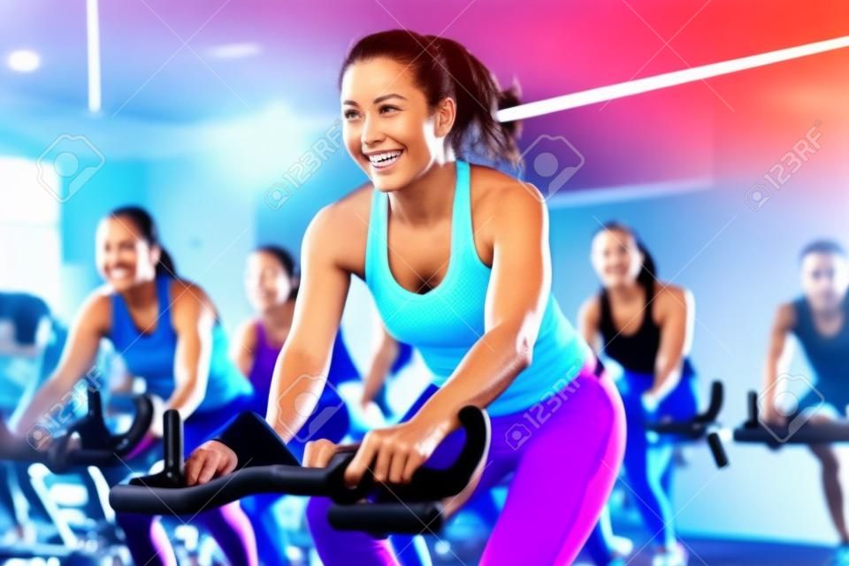 A motivational, group fitness class, featuring participants engaged in an energetic workout, such as spinning, aerobics, set against a vibrant, gym studio background. Generative AI