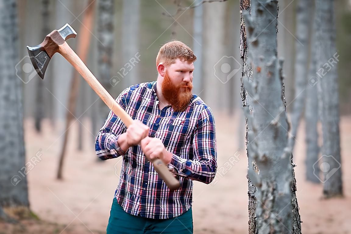 A woodcutter with ginger hair and a beard swings an ax at something. Outdoors.